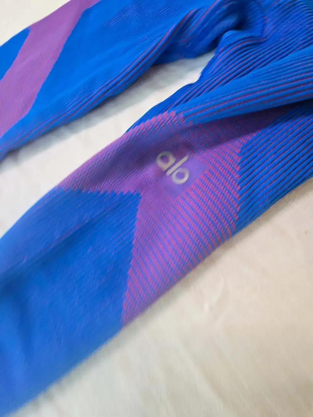 Alo Yoga Ribbed High-Waist Seamless Leggings in Blue and Purple. 025